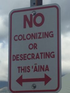 Photo of street sign, reading, "No colonizing or desecrating this 'Āina"