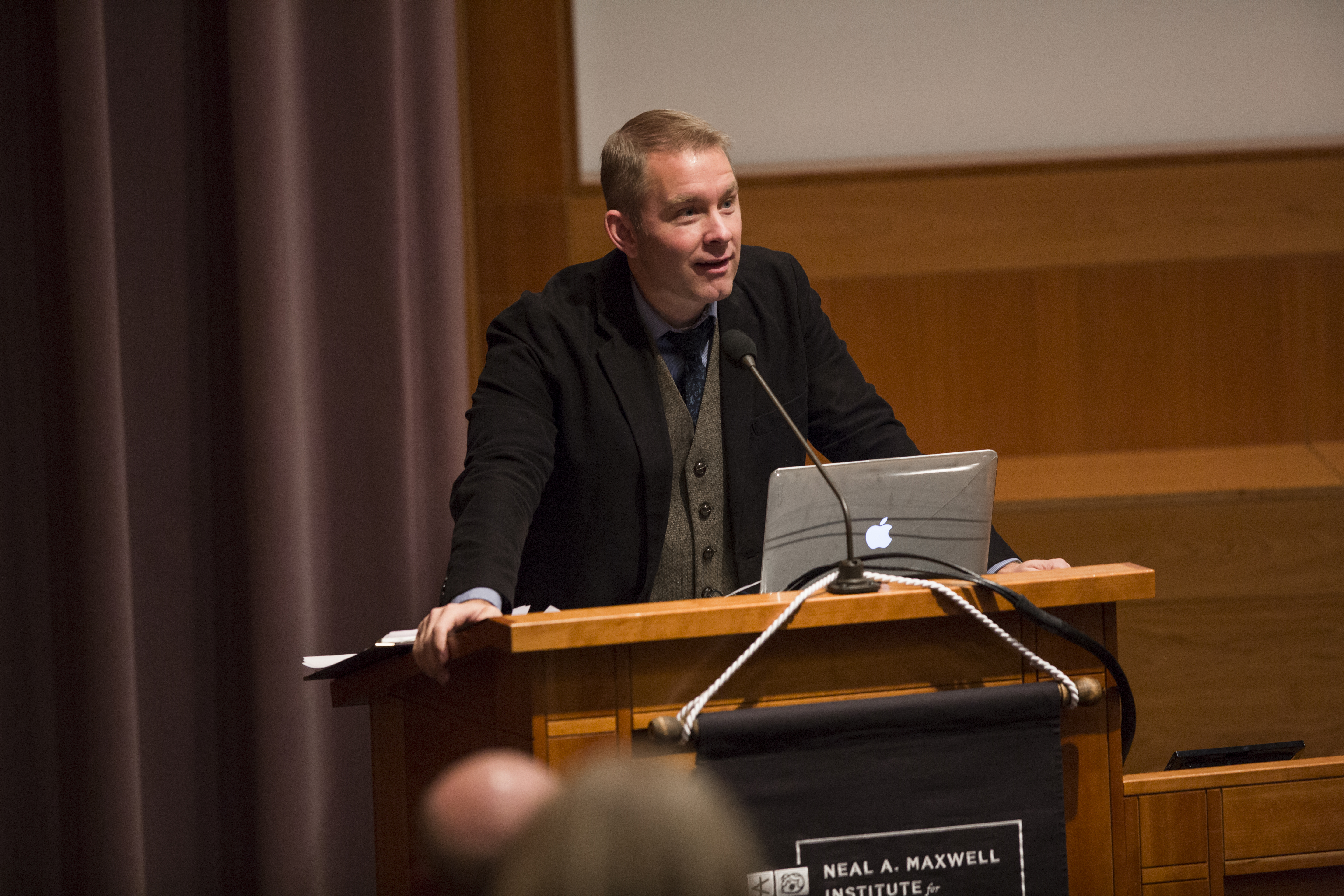 Spencer Fluhman at a podium in a lecture hall