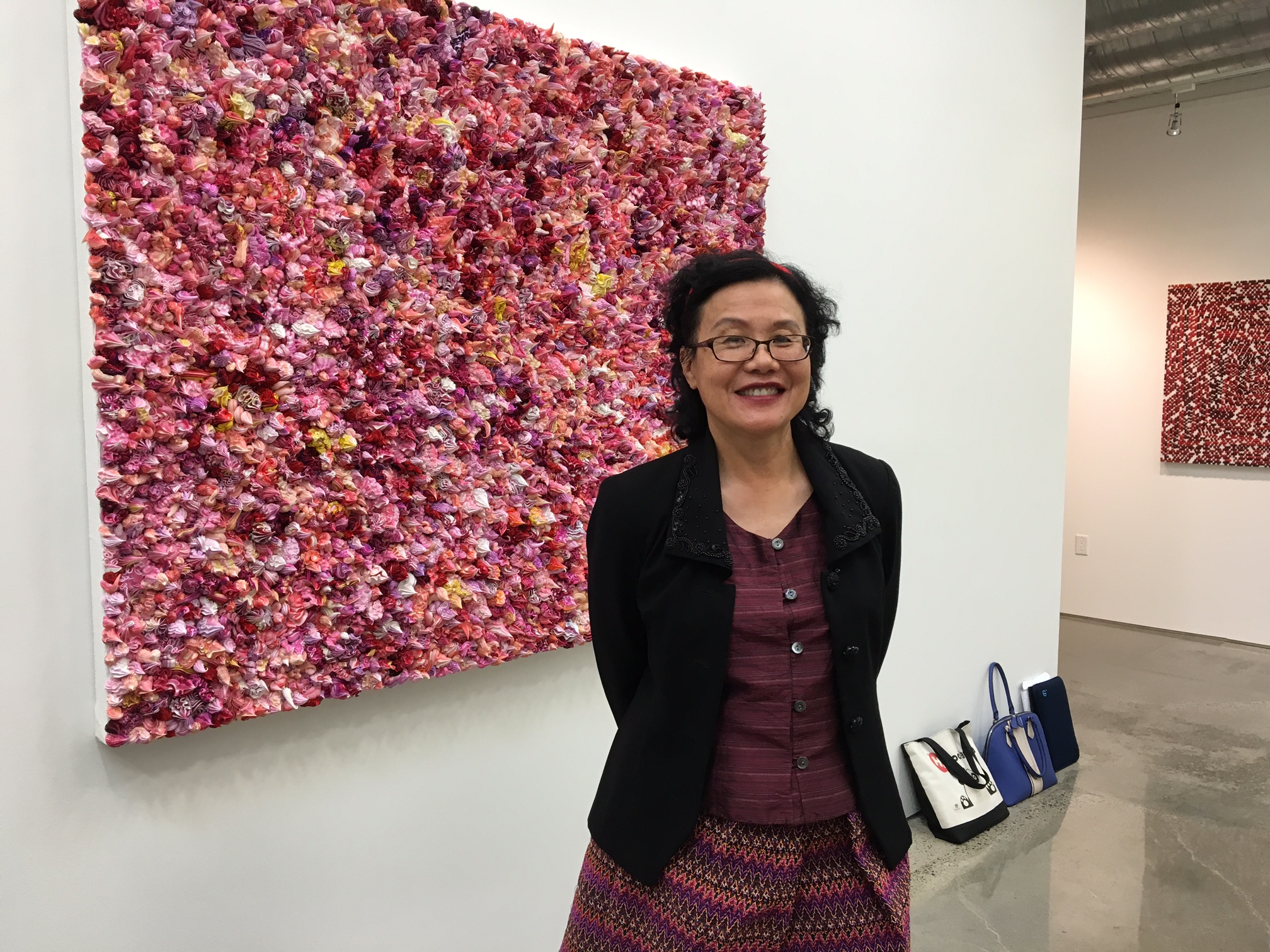 Mayfair Yang at art exhibit in front of art piece