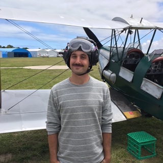 Kolby Knight with flight helmet and old fashioned plan in the background