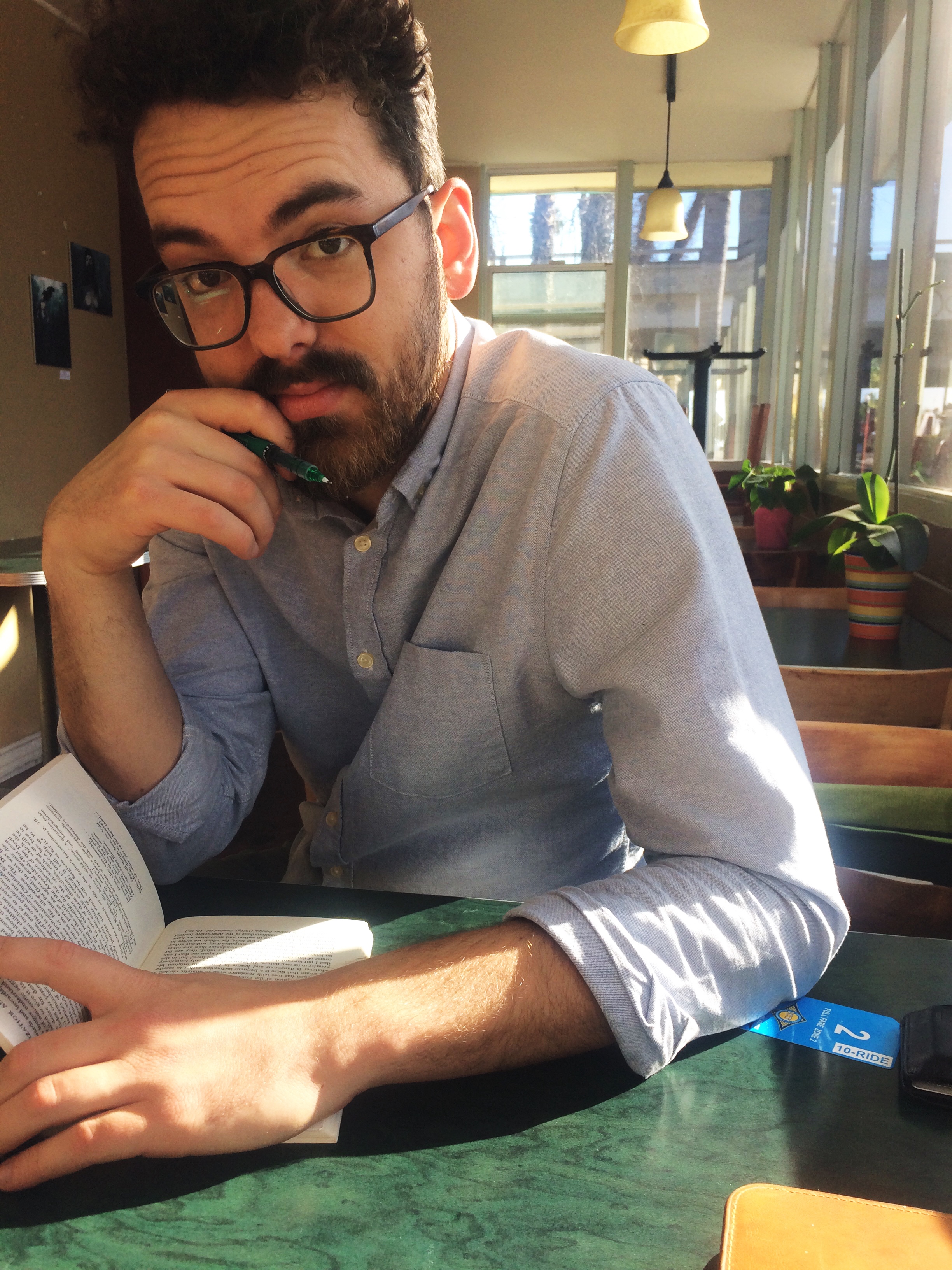 Timothy Snediker sitting at restaurant table reading a book
