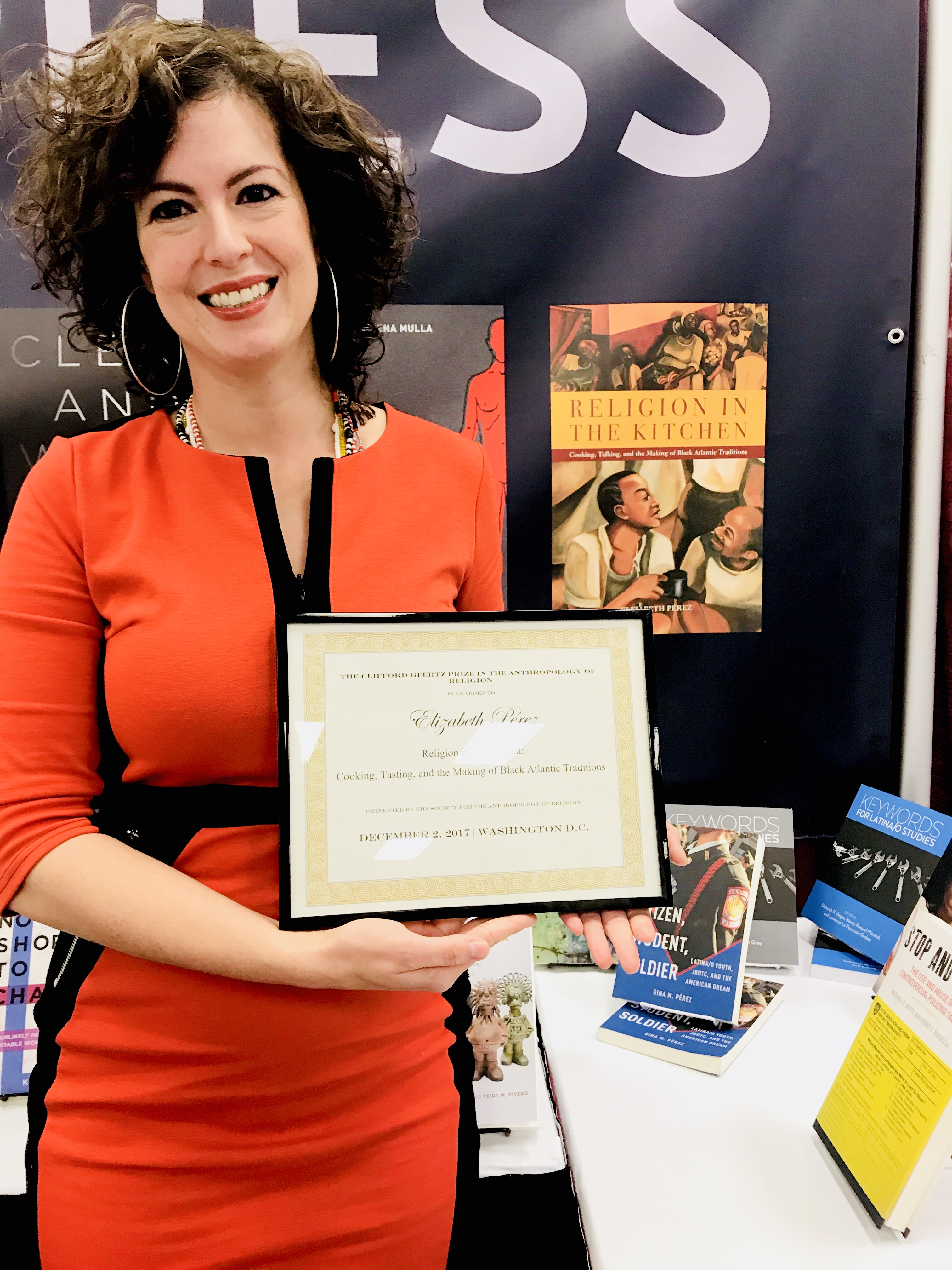 Elizabeth Pérez Heashot at event with books on table behind her