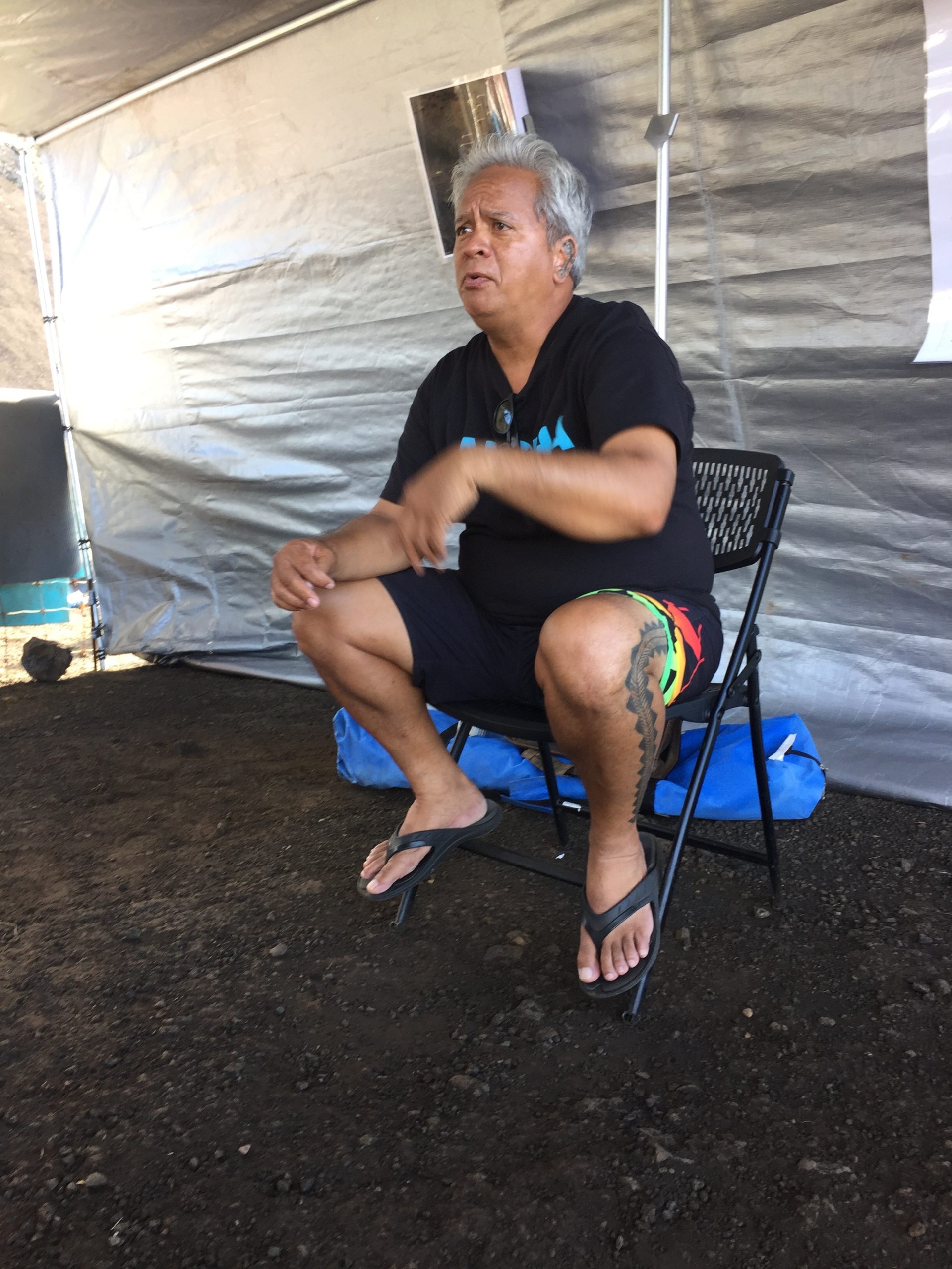 Man sitting in chair talking at indigenous event