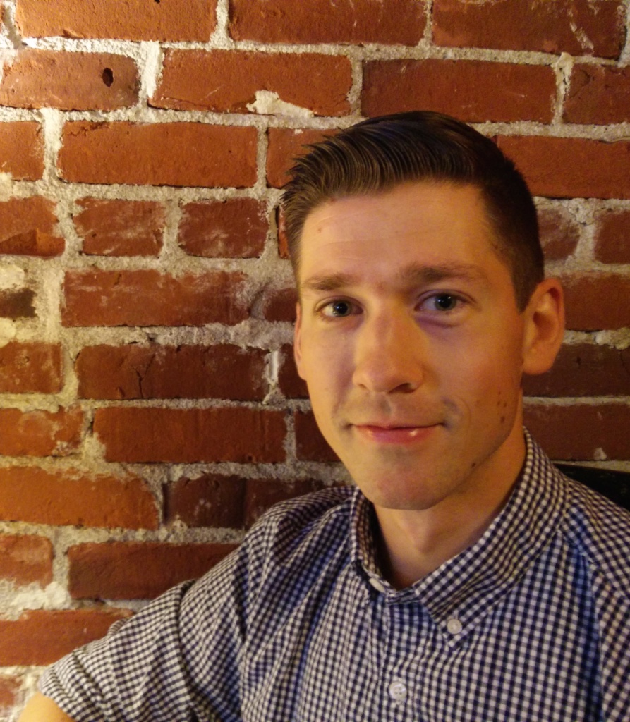 Jaakko Takkinen headshot in front of brick wall