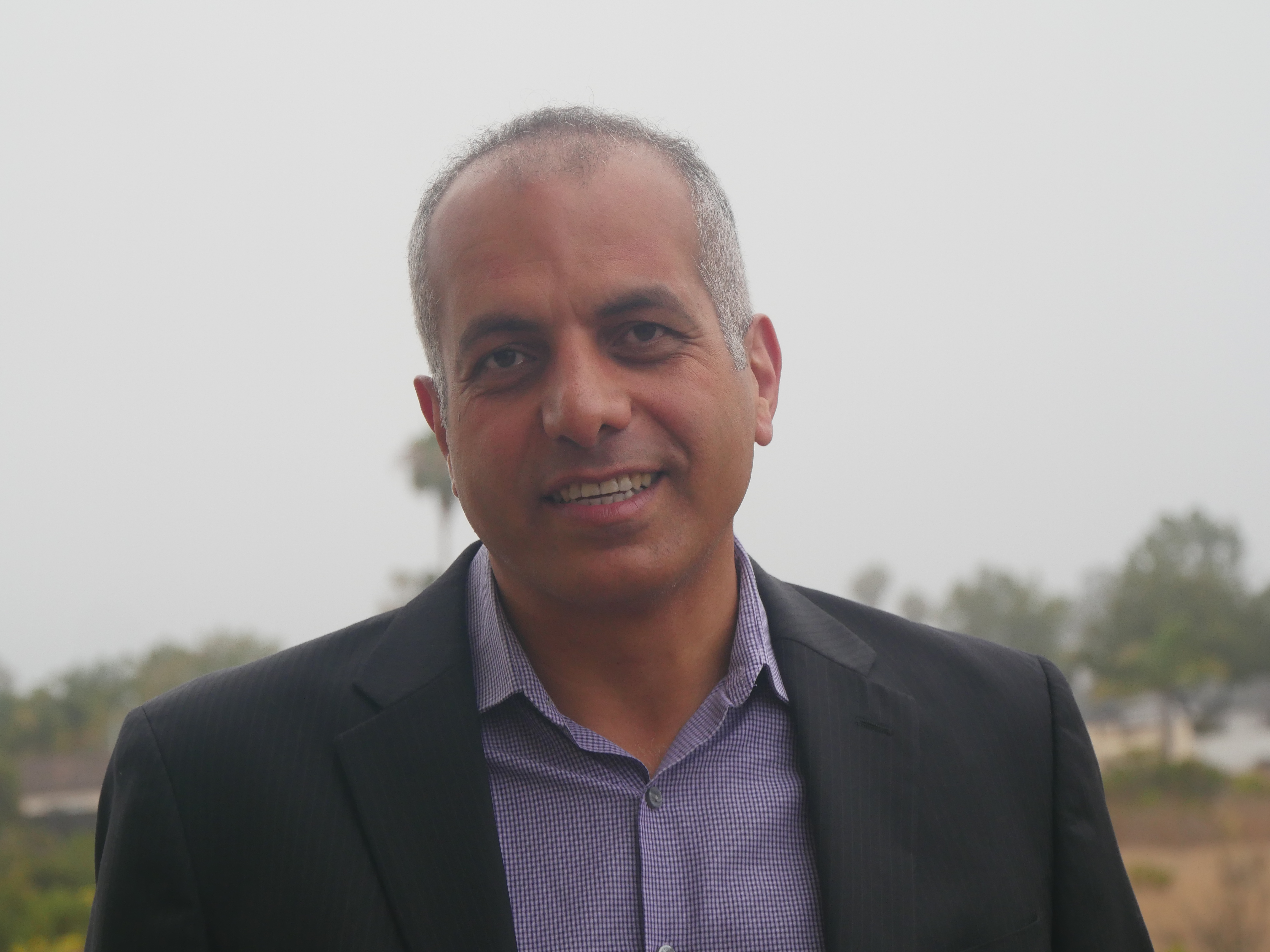 Ahmad Atif Ahmad headshot in front of outdoor backgound